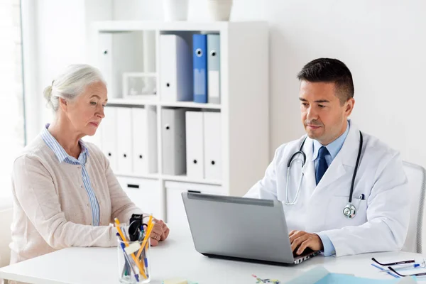 Femme âgée et médecin avec ordinateur portable à l'hôpital — Photo