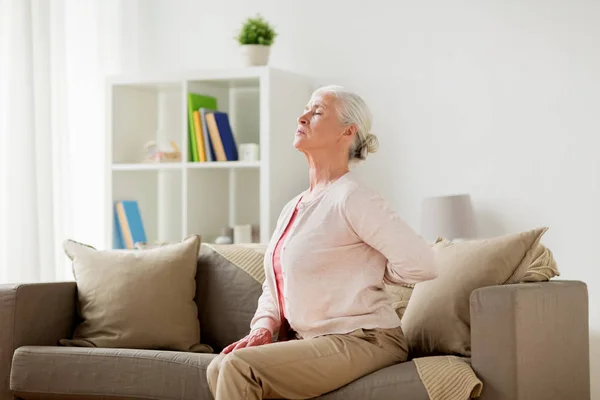 Senior woman suffering from pain in back at home — Stock Photo, Image