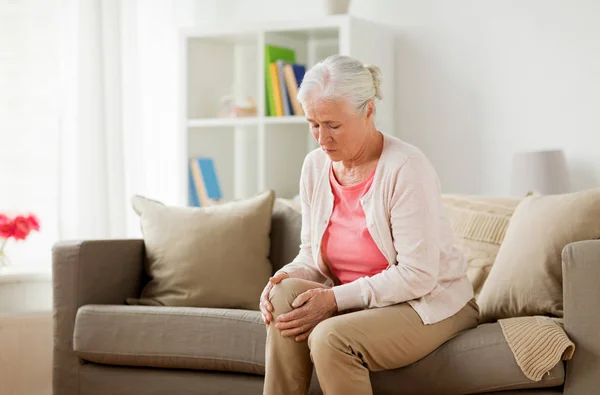 Старша жінка, яка страждає від болю в нозі вдома — стокове фото