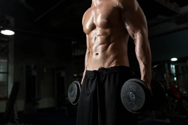 Close up de homem com halteres exercitando no ginásio — Fotografia de Stock