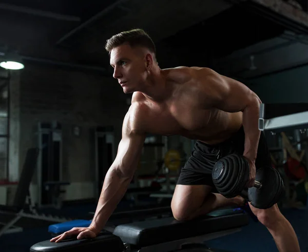 Man with dumbbell and bench exercising in gym — Stock Photo, Image