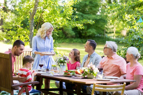 행복 한 가족 이 저녁 식사나 여름 정원 파티를 하는 모습 — 스톡 사진
