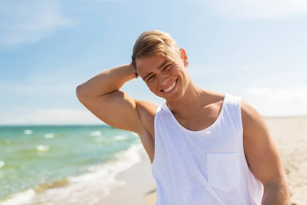 Jeune homme souriant sur la plage d'été — Photo