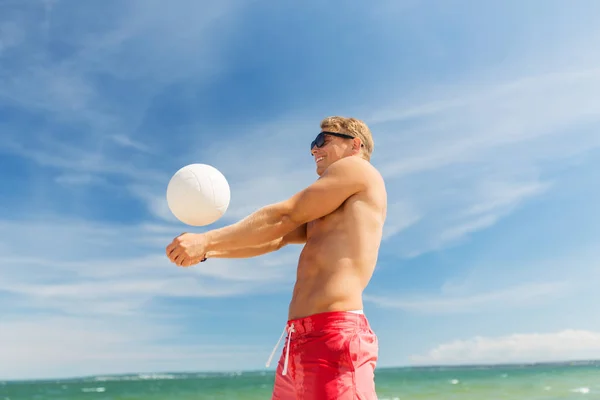 Genç adam plajda voleybol oynuyor. — Stok fotoğraf