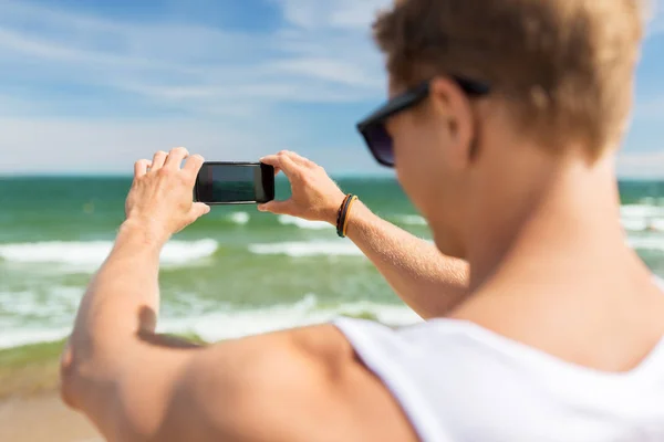 Homem com smartphone fotografando na praia de verão — Fotografia de Stock