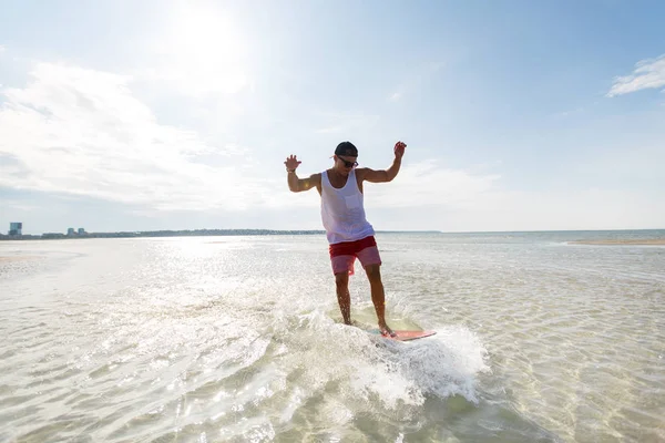 Giovane che cavalca su skimboard sulla spiaggia estiva — Foto Stock