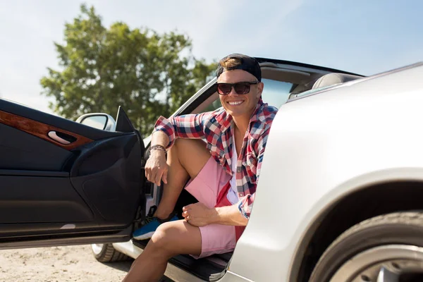 Jovem feliz sentado no carro conversível — Fotografia de Stock