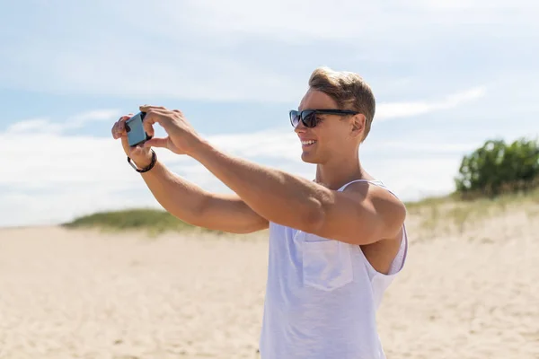 夏のビーチで撮影スマート フォンを持つ男 ストックフォト