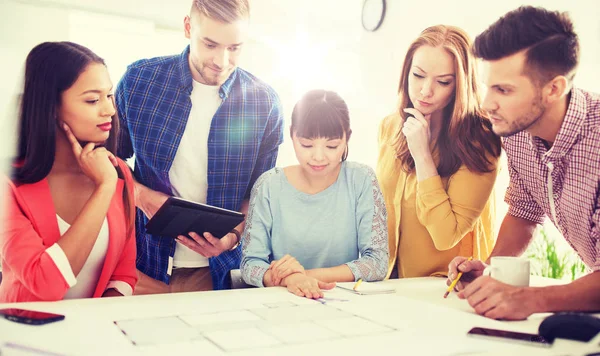 Kreativa team med blueprint arbetar på kontor — Stockfoto