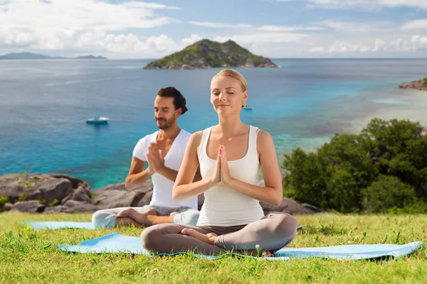 Pareja feliz haciendo yoga y meditando al aire libre —  Fotos de Stock