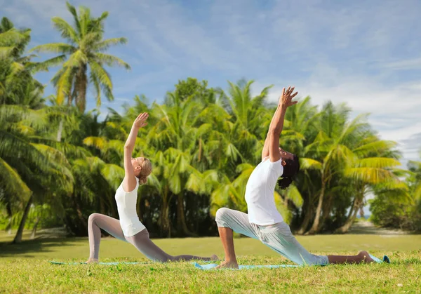 Par att göra yoga i låga utfall pose utomhus — Stockfoto