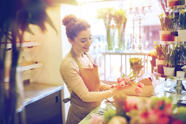 Sonriente florista mujer haciendo ramo en floristería —  Fotos de Stock