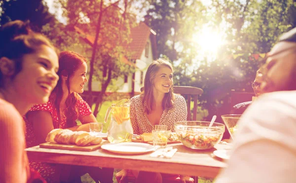 Glückliche Freunde beim Abendessen bei sommerlicher Gartenparty — Stockfoto