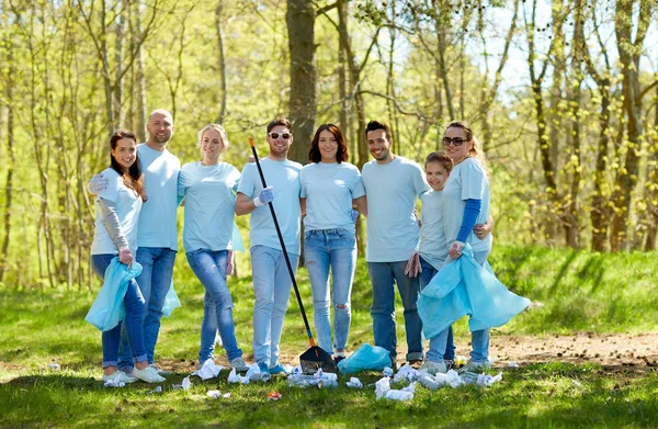 Groep vrijwilligers met vuilniszakken in park — Stockfoto