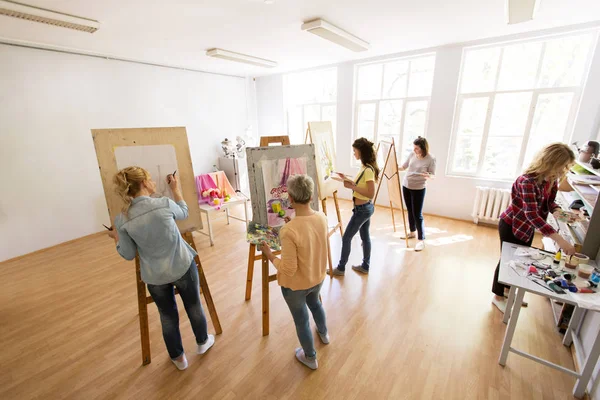 Mujeres artistas con pinceles pintura en la escuela de arte —  Fotos de Stock