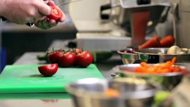 Hände eines männlichen Kochs, der Tomaten in der Küche hackt — Stockvideo