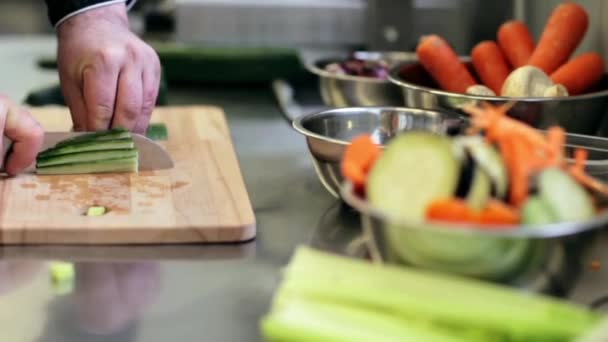 Hands of male cook chopping cucumber in kitchen — Stock Video