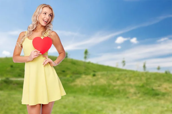 Feliz joven en vestido de verano con corazón rojo — Foto de Stock