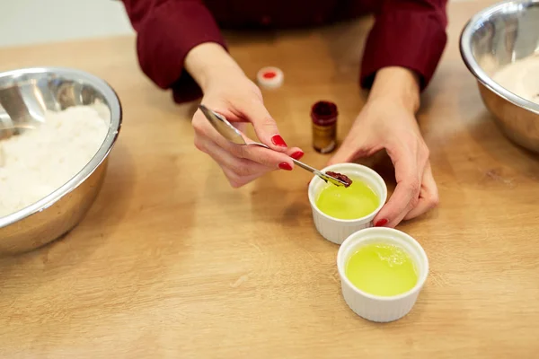 Kuchař, přidání barvu potravin do mísy, bílkem — Stock fotografie