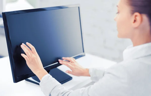 Улыбающаяся деловая женщина с сенсорным экраном в офисе — стоковое фото