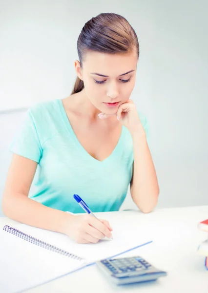 Menina estudante com notebook e calculadora — Fotografia de Stock