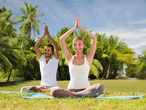 Paar doen yoga in lotus houding buitenshuis — Stockfoto