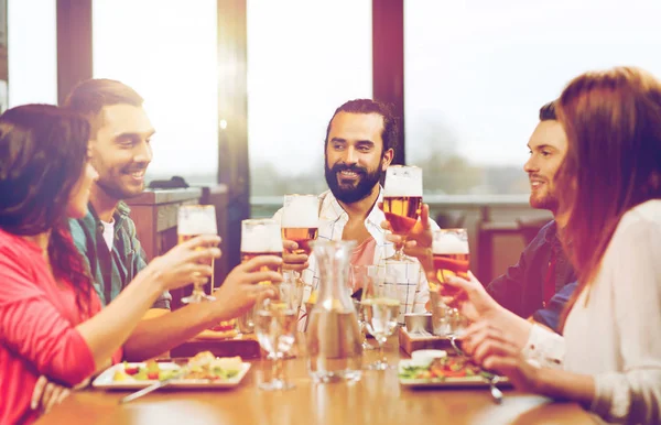 Amigos cenando y bebiendo cerveza en el restaurante —  Fotos de Stock