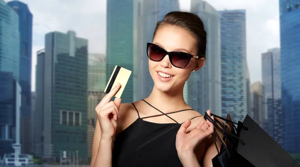 Mujer feliz con tarjeta de crédito y bolsas de compras — Foto de Stock