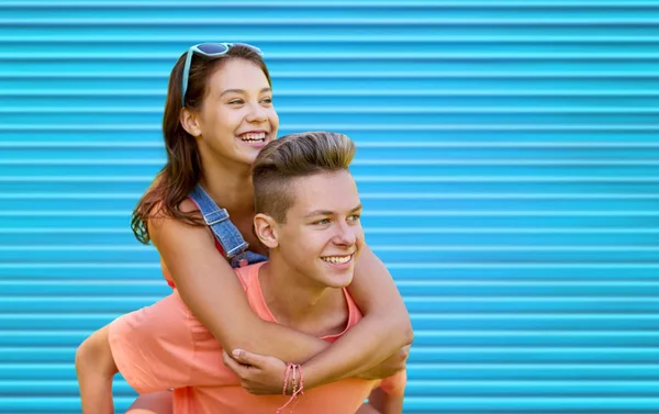Feliz pareja adolescente divirtiéndose sobre azul — Foto de Stock
