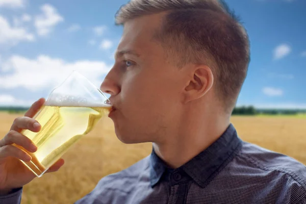 Close up of young man drinking beer from glass — Stock Photo, Image