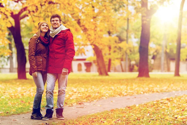 Felice giovane coppia a piedi nel parco autunnale — Foto Stock