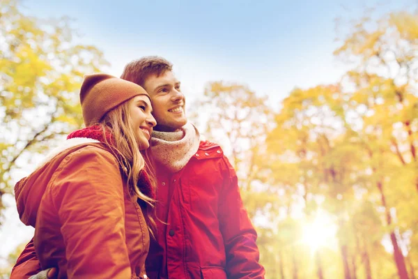 Happy young couple walking in autumn park — Stock Photo, Image