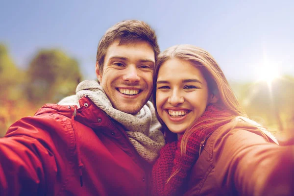 Feliz joven pareja tomando selfie en otoño parque — Foto de Stock