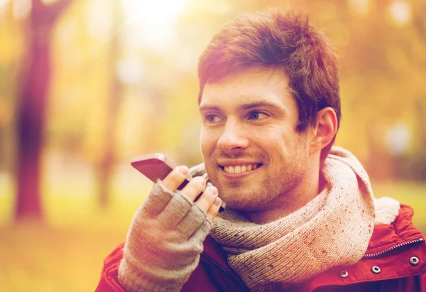 Mann nimmt Stimme auf Smartphone im Herbstpark auf — Stockfoto