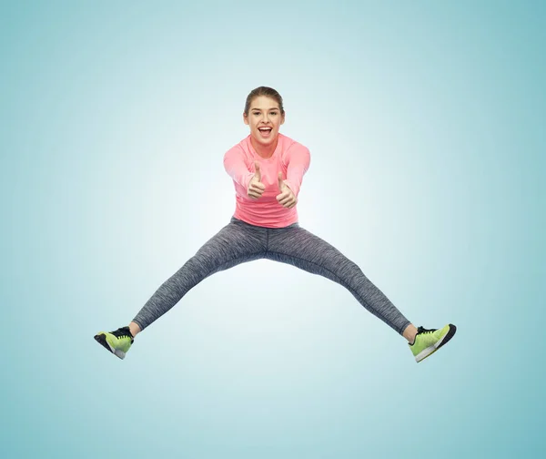 Gelukkig glimlachen sportieve jonge vrouw springen in de lucht — Stockfoto