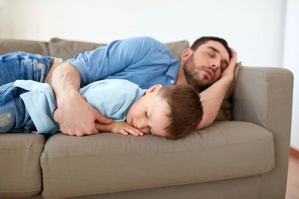 Feliz padre e hijo durmiendo en el sofá en casa —  Fotos de Stock