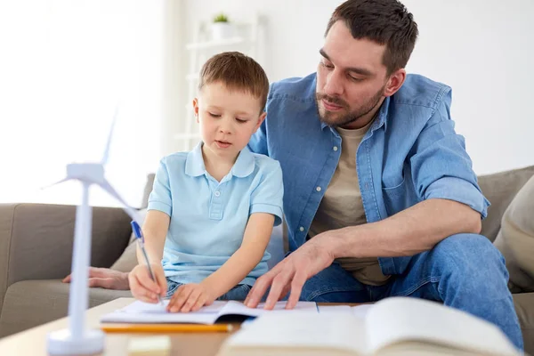 Father and son with toy wind turbine at home — Stock Photo, Image