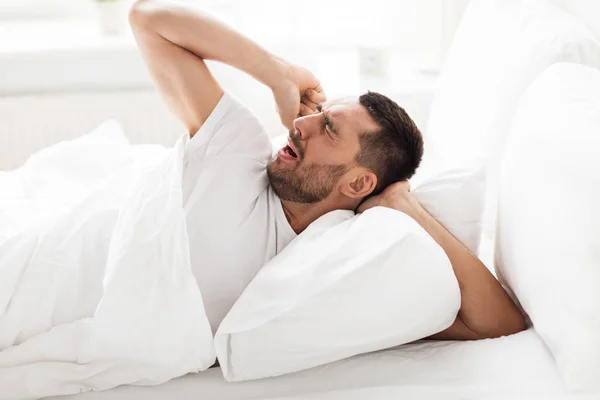 Man lying in bed at home — Stock Photo, Image