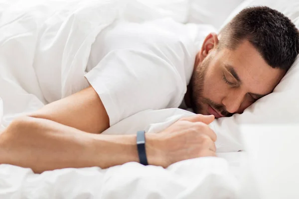 Man met smartwatch slapen in bed — Stockfoto