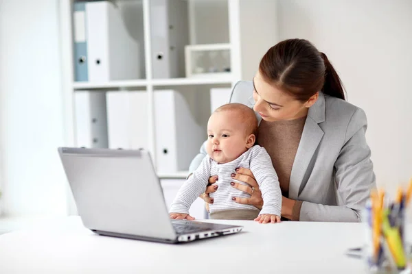 赤ちゃんとオフィスでラップトップを幸せな実業家 — ストック写真
