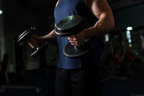Nahaufnahme eines Mannes mit Kurzhanteln beim Training im Fitnessstudio — Stockfoto