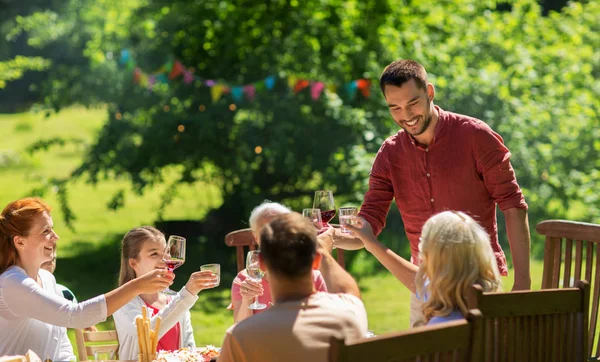 Família feliz ter jantar ou festa no jardim de verão — Fotografia de Stock