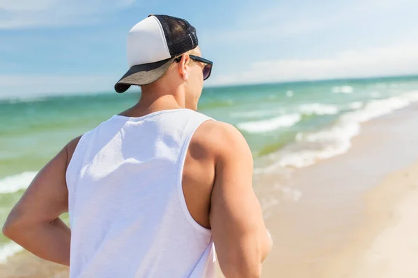 Hombre feliz corriendo a lo largo de la playa de verano —  Fotos de Stock