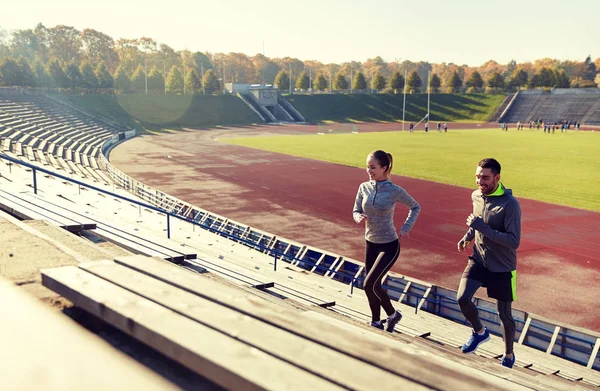 Happy couple running upstairs on stadium — Stock Photo, Image