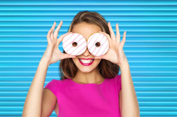 Mulher feliz ou menina adolescente olhando através de donuts — Fotografia de Stock