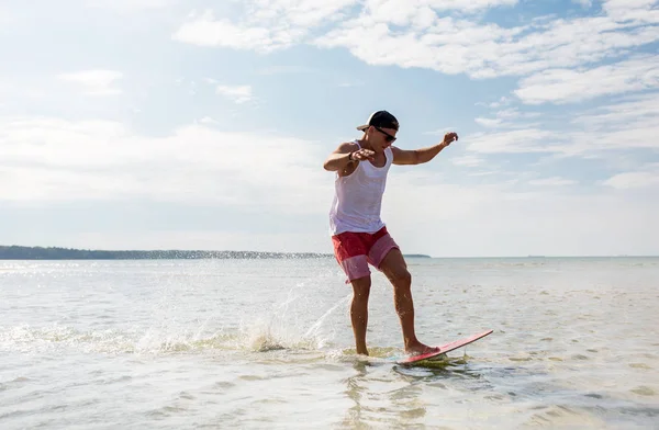 여름 해변에 skimboard 타고 젊은 남자 스톡 사진