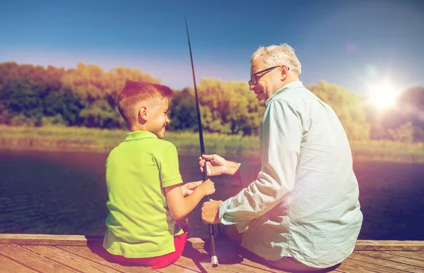 Grandfather and grandson fishing on river berth — Stock Photo, Image