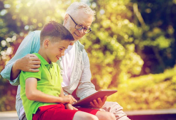 Avô feliz e menino com tablet pc ao ar livre — Fotografia de Stock