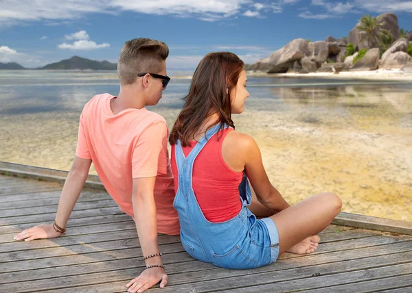 Feliz casal adolescente sentado no cais do rio — Fotografia de Stock