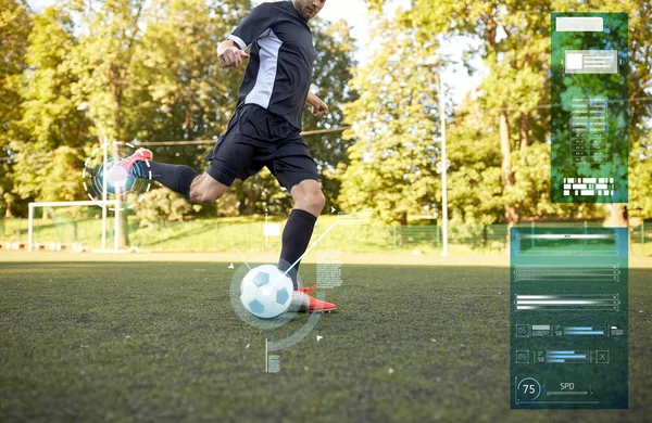 Футболист, играющий с мячом на футбольном поле — стоковое фото